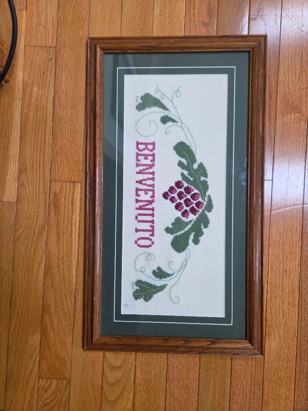 cross stitch framed embroidery piece with Italian word BENVENUTO [WELCOME]